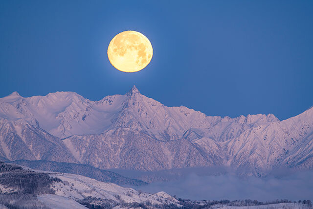 槍ヶ岳に沈まんとする満月（霧ヶ峰高原）